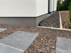 Renovatie gevel witte crepi: afwerking plint in granietpleister